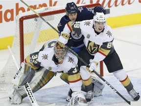 Winnipeg Jets' Matt Hendricks (15) attempts to get an opening against Las Vegas Golden Knights goalie Maxime Lagace (33) and Nate Schmidt (88) during first period NHL action in Winnipeg on Friday, December 1, 2017.