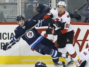 Winnipeg Jets' Josh Morrissey (44) gets checked by Ottawa Senators' Mark Stone (61) during first period NHL pre-season game action in Winnipeg on Wednesday, September 27, 2017.