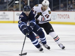 Chicago Blackhawks centre Artem Anisimov (15) chases down Winnipeg Jets defenceman Jacob Trouba (8) during second period NHL action in Winnipeg on Friday, February 10, 2017. THE CANADIAN PRESS/John Woods ORG XMIT: JGW113 ORG XMIT: POS1702102057450571
