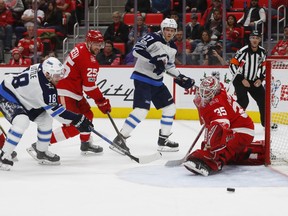 Red Wings goalie Jimmy Howard makes a save on Jets centre Bryan Little on Tuesday night in Detroit. (AP Photo/Paul Sancya)