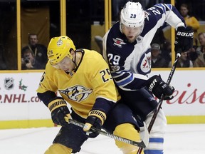 Nashville Predators defenseman Alexei Emelin (25), of Russia, and Winnipeg Jets right wing Patrik Laine (29), of Finland, battle for the puck in the first period of an NHL hockey game Monday, Nov. 20, 2017, in Nashville, Tenn.