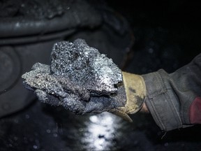 A miner shows a lump of coal. AP file photo/Mstyslav Chernov