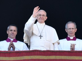 Pope Francis, centre, waves from the balcony of St Peter's basilica during the traditional "Urbi et Orbi" Christmas address and blessing given to the city of Rome and to the World, on Dec. 25, 2017 at St Peter's square in Vatican.