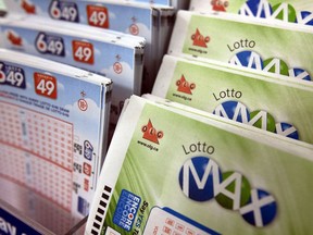Lotto MAX and Lotto 649 tickets sit in a display case on a store shelf.