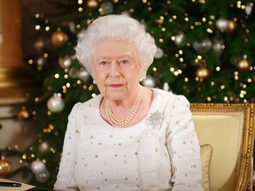 In this photo released on Monday, Dec. 25, 2017, Britain's Queen Elizabeth sits at a desk in the 1844 Room at Buckingham Palace, after recording her Christmas Day broadcast to the Commonwealth, in London. (Pool Photo via AP)