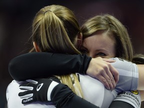 Rachel Homan, right, and Lisa Weagle hug each other after winning the 2017 Roar of the Rings Canadian Olympic Trials in Ottawa on Sunday, Dec. 10, 2017. Homan and her Ottawa-based curling team will represent Canada at the Winter Olympics. (THE CANADIAN PRESS/Adrian Wyld)