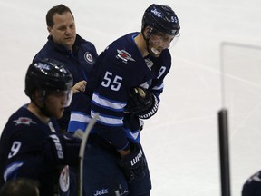 Winnipeg Jets centre Mark Scheifele clutches his right shoulder as he is helped to the bench during NHL action against the Edmonton Oilers on Dec. 27. Barring an unforeseen setback, Scheifele could be back in the Winnipeg Jets lineup as early as next Friday against the St. Louis Blues.