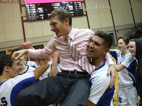 Assistant coach Michael Singleton is hoisted by Nigel Nielsen after the Lord Selkirk Royals defeated the River East Kodiaks in the AAAA provincial boys high school volleyball championship game at Investors Group Athletic Centre on Monday night. (Kevin King/Winnipeg Sun)