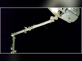 In this image taken from NASA Television, the robotic arm reaches out and captures the SpaceX Dragon cargo spacecraft for docking to the International Space Station, Sunday Dec. 17, 2017. (NASA via AP)
