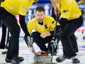 Skip Mike McEwen watches his rock as second Matt Wozniak and lead Denni Neufeld sweep during Olympic curling trials action against Team Koe on Dec. 5, 2017