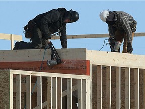 Tradespeople work on new housing construction.