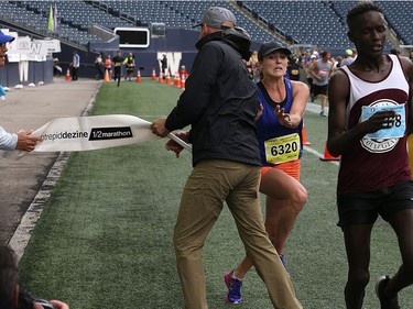 YEAR IN REVIEW: Manitoba Marathon half-marathon female winner Jaclyn Adamson of Winnipeg nearly collides with a race official holding the finish-line tape at Investors Group Field in Winnipeg on Sun., June 18, 2017. Kevin King/Winnipeg Sun/Postmedia Network ORG XMIT: POS1706181141022226