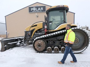 Polar Industries, in Winnipeg, is preparing to transport goods to Churchill by land.  Mark Kohaykewych, President of Polar Industries Ltd. walks past a bull dozer destined for Churchill.   Friday, December 15, 2017.   Sun/Postmedia Network