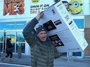 Ray Bjelland exits the Best Buy in the Crossroads Station Shopping Centre on Regent Avenue in Winnipeg with a new television on Tuesday.