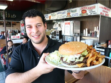 Peter Scouras, owner of the Red Top Drive Inn in Winnipeg, displays a burger and fries Friday in a 2011 file photo. Scouras died while swimming in Costa Rica on Monday, Feb. 20. He was 33. BRIAN DONOGH/WINNIPEG SUN/QMI AGENCY