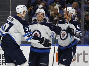 Jets’ Nikolaj Ehlers (centre) celebrates one of his two goals last night against Buffalo. Ehlers had gone nine games without a tally. (AP PHOTO)