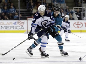 Winnipeg Jets winger Joel Armia (left) tries to get by San Jose Sharks defenceman Brenden Dillon last night. (AP)