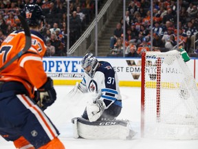 Connor McDavid (97) of the Edmonton Oilers can't get the puck past goaltender Connor Hellebuyck (37) of the Winnipeg Jets during National Hockey League action at Rogers Place in Edmonton on Sunday, Dec. 31, 2017.
