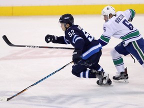 Winnipeg Jets' Jack Roslovic (52) and Vancouver Canucks' Brock Boeser (6) chase the puck during first period NHL hockey action in Winnipeg, Sunday, January 21, 2018.
