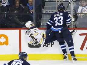 Winnipeg Jets' Dustin Byfuglien (33) checks Buffalo Sabres' Zemgus Girgensons (28) during third period NHL action in Winnipeg on Friday, January 5, 2018. THE CANADIAN PRESS/John Woods ORG XMIT: JGW115