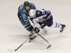 San Jose Sharks center Joe Thornton (19) and Winnipeg Jets right wing Blake Wheeler (26) reach for the puck during the first period of an NHL hockey game in San Jose, Calif., Saturday, Nov. 25, 2017.