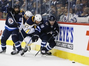 Winnipeg Jets’ Mathieu Perreault (left) and Bryan Little (right) scramble for the loose puck against the Sabres on Friday night. (THE CANADIAN PRESS)