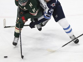 Minnesota Wild's Zach Parise (11) fights for possession of the puck against Winnipeg Jets' Blake Wheeler (26) during the third period Saturday.