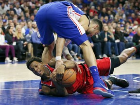 Toronto Raptors guard Kyle Lowry and Philadelphia 76ers guard Ben Simmons vie for a loose ball during an NBA game on Jan. 15, 2018
