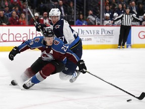 Colorado Avalanche centre Nathan MacKinnon (front) fights for the puck with Winnipeg Jets defenceman Tyler Myers. (AP)