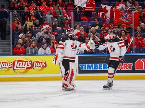 Canada's Cale Makar celebrates a goal with goalie Carter Hart on Dec. 30, 2017