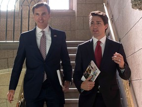 Finance Minister Bill Morneau and Prime Minister Justin Trudeau hold copies of the federal budget on their way to the House of Commons in Ottawa, Wednesday, March 22, 2017.