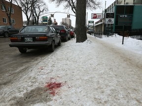 Blood remains near the sidewalk on Corydon Avenue near Bar Italia on Sunday. Police are investigating a stabbing that occurred in the early morning hours.