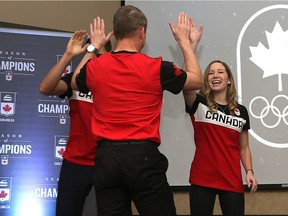 Canada's mixed doubles curling team for the 2018 Olympics in Pyeongchang, South Korea, Kaitlyn Lawes (right) and John Morris (left) high-five coach Jeff Stoughton during a Canadian Olympic Committee and Curling Canada event at Canad Inns Polo Park on Monday.