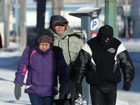 Pedestrians brace against the cold while walking on Princess Street in the 'Mission District' of Winnipeg on Monday.