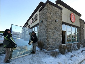 Security Glass prepares a new pane for placement at G is for Glasses on Taylor Avenue in Winnipeg on Monday. The store was broken into during the early morning hours of Sunday. Three men are in custody.