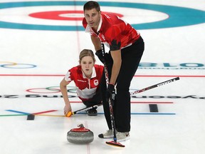 John Morris and Kaitlyn Lawes of Canada deliver a stone during the Curling Mixed Doubles at 2018 Winter Olympics.