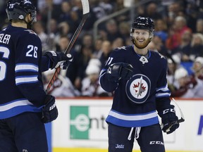 Jets Kyle Connor (right) and Blake Wheeler celebrate a second-period goal during a 6-1 pounding of the Avs last night. (The Canadian Press)