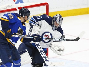 Winnipeg Jets goaltender Connor Hellebuyck (37) stops a shot deflected by St. Louis Blues' Brayden Schenn, left, during the third period of an NHL hockey game Friday, Feb. 23, 2018, in St. Louis. The Jets open the 2018-19 season at St. Louis on Oct. 4. AP Files