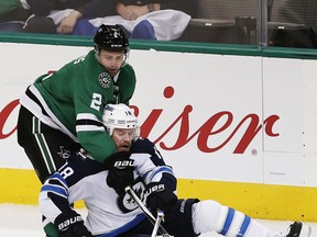 Dallas Stars defenceman Dan Hamhuis (2) and Winnipeg Jets forward Bryan Little (18) battle for the puck during the second period Saturday in Dallas.