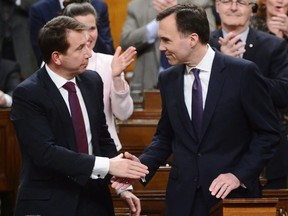 Finance Minister Bill Morneau, right, is congratulated by Treasury Board President Scott Brison after delivering the federal budget in the House of Commons in Ottawa on Tuesday, Feb. 27, 2018. Brison announced this week he'll be stepping away from politics.
