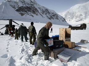 FILE - In this April 15, 2002, file photo, members of the U.S. Army's High Altitude Rescue Team from Fort Wainwright Army Base near Fairbanks, Alaska, unload supplies from the team's CH-47 Chinook helicopters for the National Park Service's 7,000-foot level Mount McKinley base camp on the Kahiltna Glacier near Talkeetna, Alaska. The National Park Service is considering new rules for the disposal of human waste generated by climbers on North America's tallest mountain, Denali.