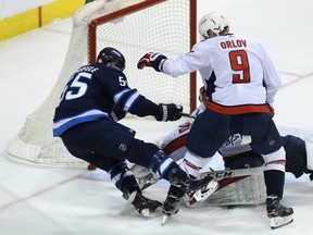 Winnipeg Jets centre Mark Scheifele (left) is hit by Washington Capitals defenceman Dmitry Orlov last night. (Kevin King/Winnipeg Sun)