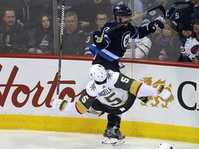 Winnipeg Jets centre Adam Lowry (top) levels Vegas Golden Knights defenceman Deryk Engelland with a shoulder check in Winnipeg on Thurs., Feb. 1, 2018. Kevin King/Winnipeg Sun/Postmedia Network