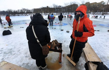 People warm up by the fire during the 17th annual Ironman Outdoor Curling Bonspiel on the Red River at The Forks in Winnipeg on Sun., Feb. 4, 2018. Kevin King/Winnipeg Sun/Postmedia Network