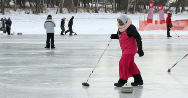 A sweeper travels with the rock during the 17th annual Ironman Outdoor Curling Bonspiel on the Red River at The Forks in Winnipeg on Sun., Feb. 4, 2018. Kevin King/Winnipeg Sun/Postmedia Network