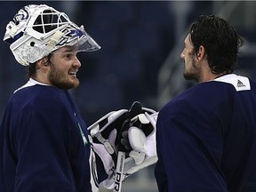 Goaltenders Michael Hutchinson (left) and Connor Hellebuyck chat during Winnipeg Jets practice at Bell MTS Place in Winnipeg on Mon., Feb. 5, 2018. Kevin King/Winnipeg Sun/Postmedia Network