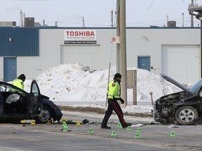 Police investigators work at the scene of a two-vehicle collision on Dufferin Avenue west of Notre Dame Avenue in Winnipeg on Sun., Feb. 11, 2018. Kevin King/Winnipeg Sun/Postmedia Network