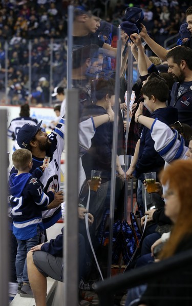 Dustin Byfuglien receives items to autograph from the stands behind the glass during the Winnipeg Jets skills competition at Bell MTS Place in Winnipeg on Wed., Feb. 14, 2018. Kevin King/Winnipeg Sun/Postmedia Network