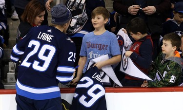 Patrik Laine signs a jersey with his name and number for a young fan during the Winnipeg Jets skills competition at Bell MTS Place in Winnipeg on Wed., Feb. 14, 2018. Kevin King/Winnipeg Sun/Postmedia Network