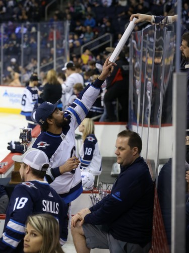 Dustin Byfuglien receives items to autograph from the stands behind the glass during the Winnipeg Jets skills competition at Bell MTS Place in Winnipeg on Wed., Feb. 14, 2018. Kevin King/Winnipeg Sun/Postmedia Network